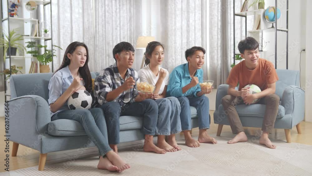 Asian Teenagers Cheering And Watching Football Game On Tv. Team Celebrating Victory And Team Disappointed
Asian Teenagers Cheering And Watching Football Game On Tv. Team Celebrating Victory And Team Disappointed