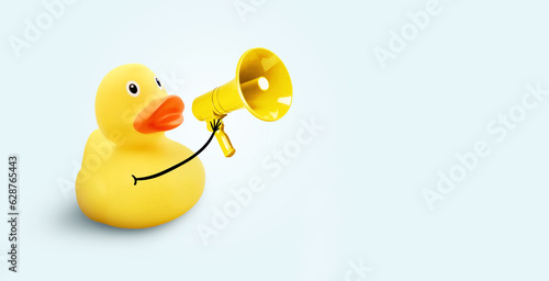 Fotografia Creative funny yellow duck holding a loudspeaker on a blue background