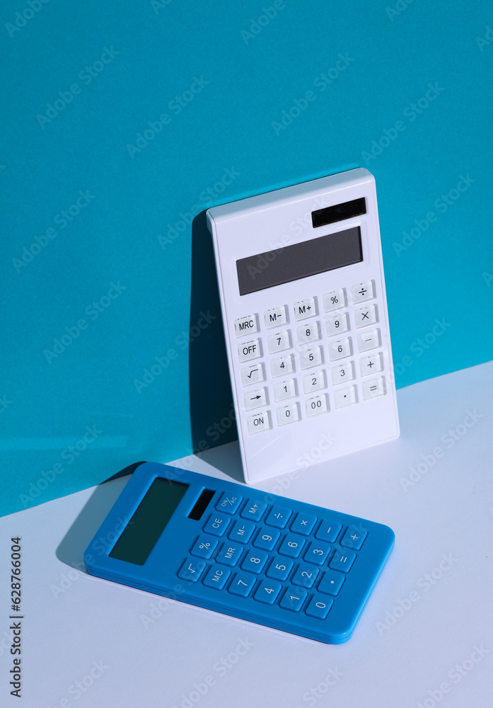 Two Calculators on a blue white background. Minimalism, conceptual business or education photo, creative layout Two Calculators on a blue white background. Minimalism, conceptual business or education photo, creative layout