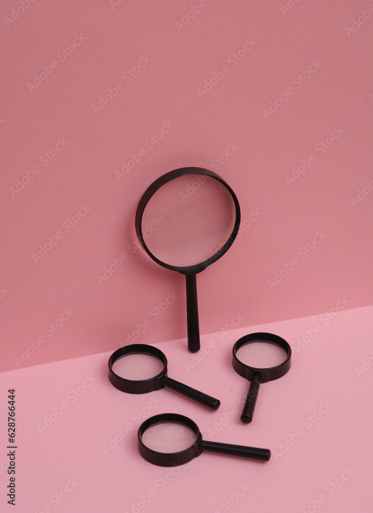 Magnifying glasses on pink background. Creative layout. Minimal business concept. Conceptual still life Magnifying glasses on pink background. Creative layout. Minimal business concept. Conceptual still life