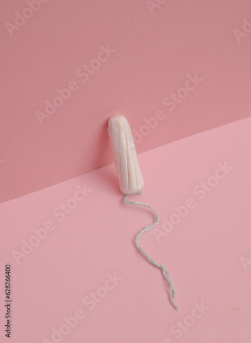 Tampon on a pink background. Menstruation, feminine hygiene © splitov27