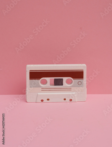 Outdated technologies. Retro 80s audio cassette on pink background. Creative layout