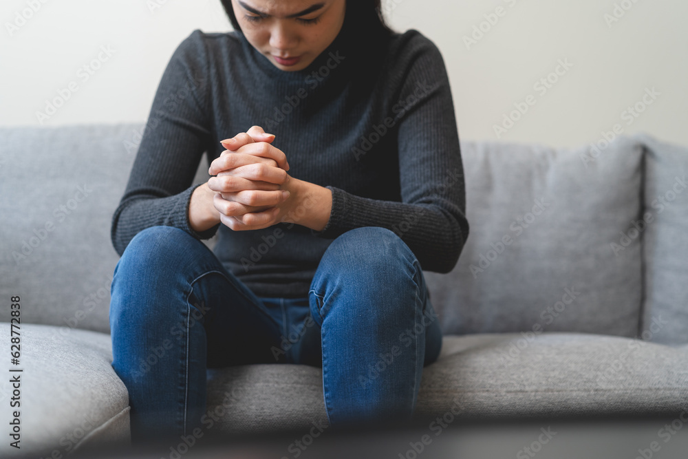 Φωτογραφία Unhappy anxiety young Asian woman covering her face with pillow on the cough in the living room at home