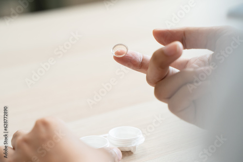 Obraz na plátne Optimise vision by contact lens, Close-up of woman face during insert contact lens to her eyes