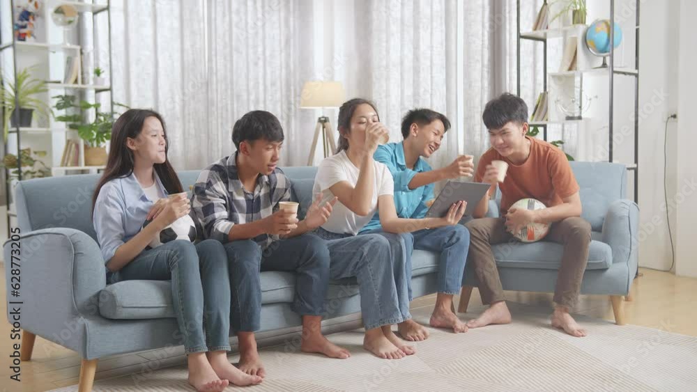 Asian Teenagers Cheering, Eating And Drink While Watching Football Game On Tablet At Home
Asian Teenagers Cheering, Eating And Drink While Watching Football Game On Tablet At Home