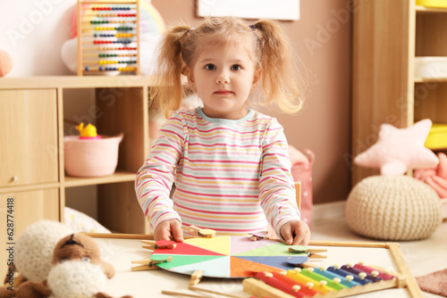 Cute little girl playing ma...