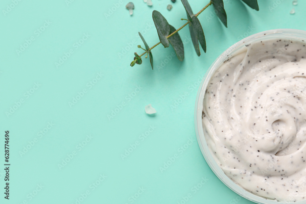 Fototapeta premium Jar of body scrub and eucalyptus branch on color background