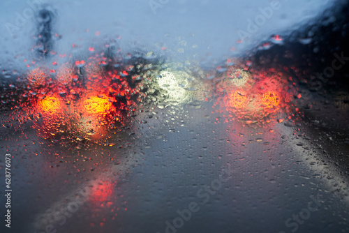 Raindrops on the car window. Bad weather and low visibility on the highway.