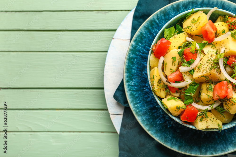 Bowl of tasty Potato Salad with vegetables on green wooden background, closeup Bowl of tasty Potato Salad with vegetables on green wooden background, closeup