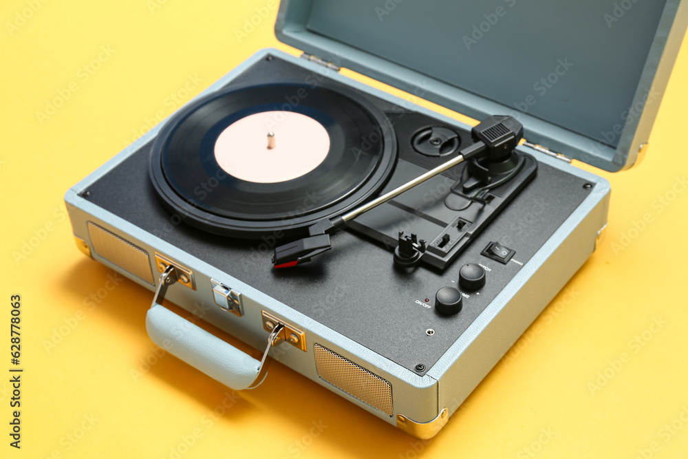 Record player with vinyl disk on yellow background, closeup Record player with vinyl disk on yellow background, closeup
