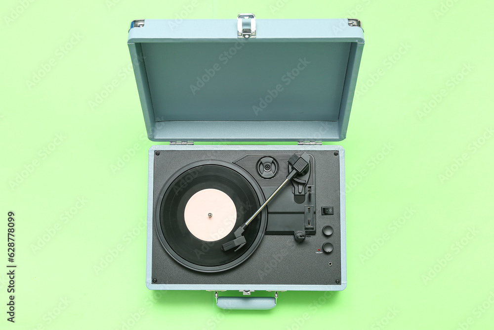 Fototapeta premium Record player with vinyl disk on green background