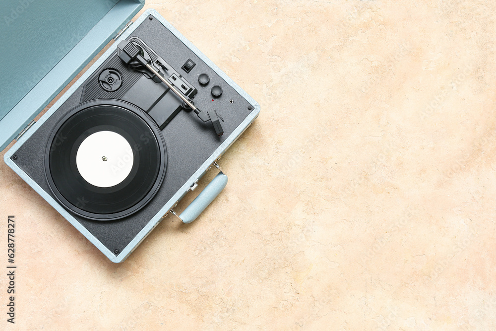 Fototapeta premium Record player with vinyl disk on beige background