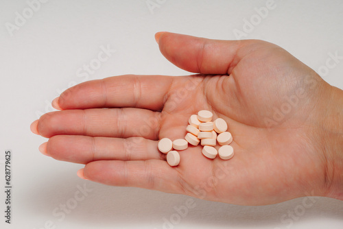 Different types of pills in a woman s hand