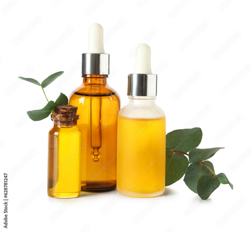 Bottles with cosmetic oil and eucalyptus branch on white background Bottles with cosmetic oil and eucalyptus branch on white background