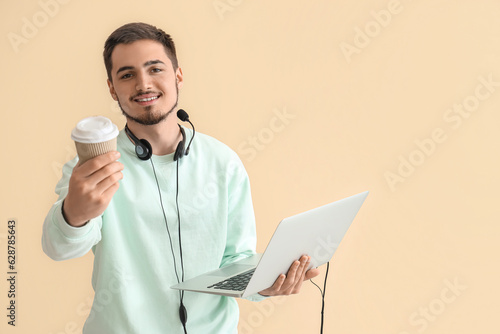 Wallpaper Mural Male technical support agent with laptop and coffee on beige background Torontodigital.ca