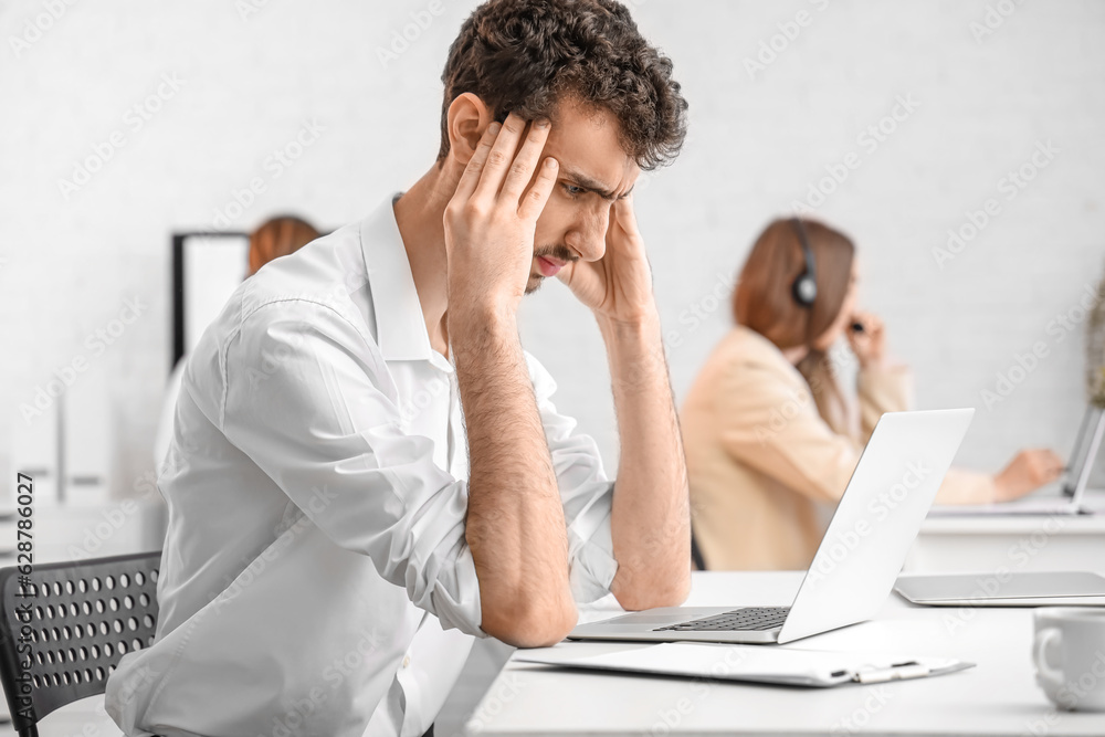 Tired male office worker at workplace Tired male office worker at workplace