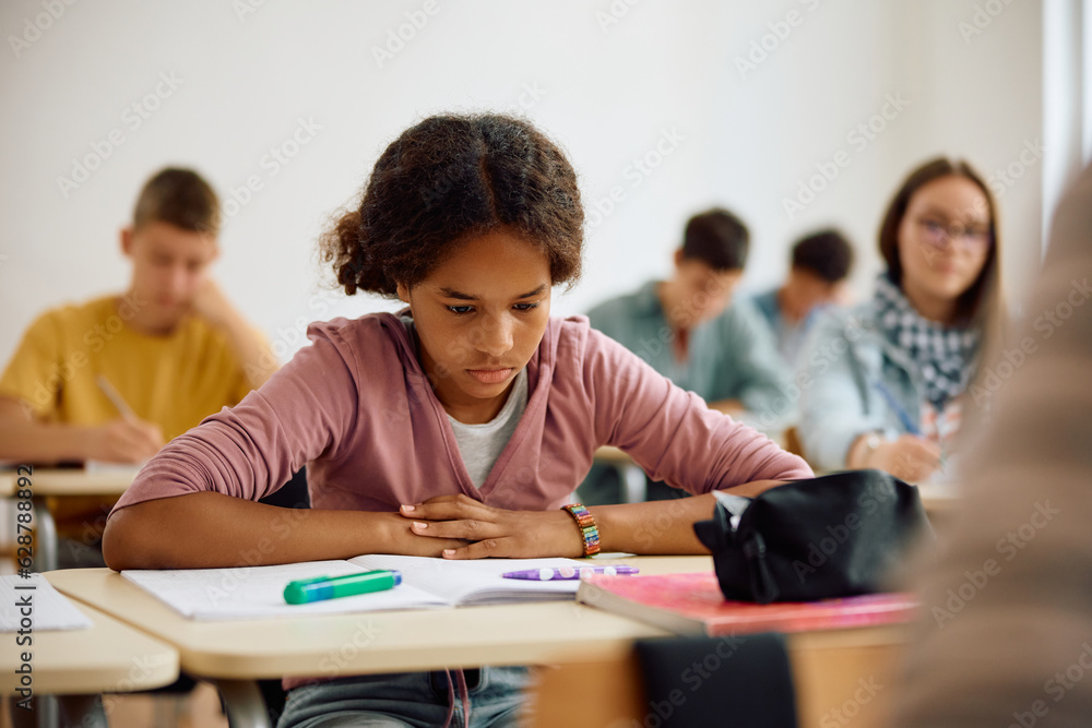 Black female student learning in classroom at high school. Black female student learning in classroom at high school.