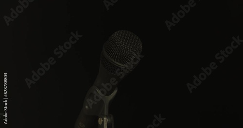 Microphone transitions from obscurity to illumination, then obscurity (fast) photo