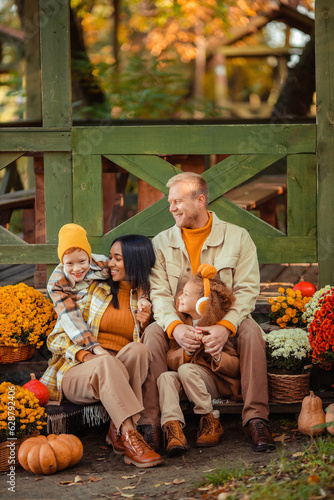 family traditions. multiethnic family i am in autumn in the park in a wooden gazebo next to pumpkins and flowers