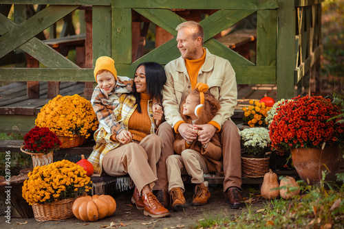 family traditions. multiethnic family i am in autumn in the park in a wooden gazebo next to pumpkins and flowers