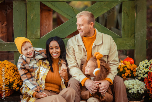 family traditions. multiethnic family i am in autumn in the park in a wooden gazebo next to pumpkins and flowers