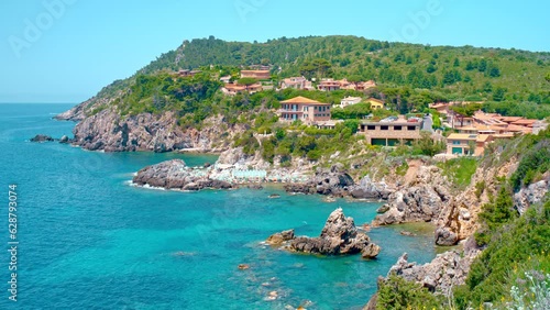 Talamone rocky beach and medieval fortress Rocca Aldobrandesca and walls. The village lies on a rocky promontory, in Maremma nature reserve, mount Argentario, Tuscany, Italy photo