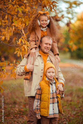 happy father with children on a walk in the autumn park. father s day