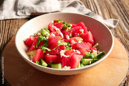 Bowl of tasty watermelon salad on wooden background
