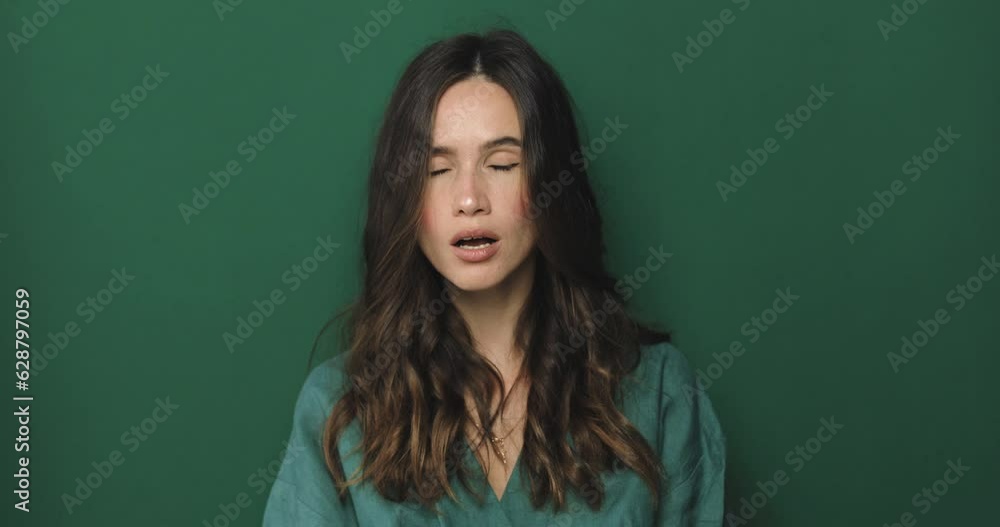 Serious brunette curly woman placing finger hand on lips, shh gesture, be quiet, silence, isolated green background. Negative facial expression, sign, emotion, feelings, body language. Serious brunette curly woman placing finger hand on lips, shh gesture, be quiet, silence, isolated green background. Negative facial expression, sign, emotion, feelings, body language.