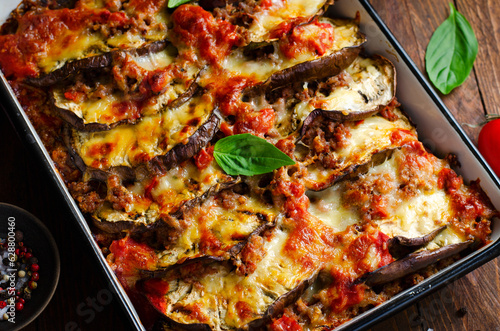 Eggplant Casserole, Roasted Eggplant Dish with Minced Meat, Tomato Sauce and Mozzarella over Rustic Background
