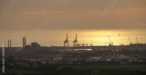 Strand von Livorno in Italien mit Industriehafen bei Sonnenuntergang Abendrot