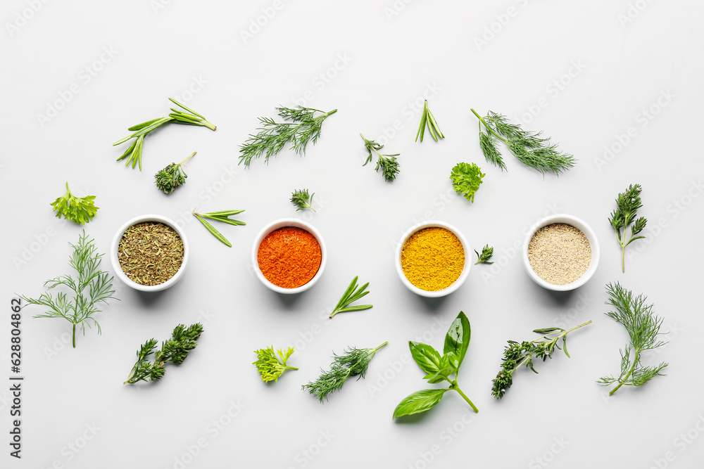 Composition with bowls of spices and fresh herbs on light background - obrazy, fototapety, plakaty 