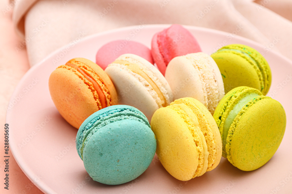 Plate with sweet macaroons on pink background Plate with sweet macaroons on pink background