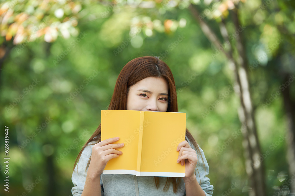 A beautiful woman, a college student, reading in a forest park A beautiful woman, a college student, reading in a forest park