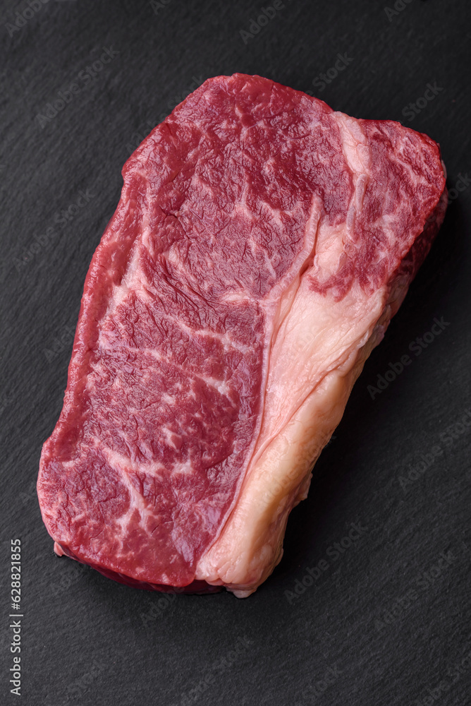 Fresh raw beef striploin steak with salt, spices and herbs Fresh raw beef striploin steak with salt, spices and herbs