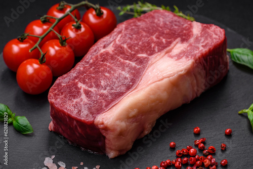 Fresh raw beef striploin steak with salt, spices and herbs