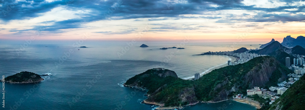 Panoramic of Rio city, Brazil at sunset, cityscape at Atlantic ocean background. Panorama aerial view of landscape Rio de Janeiro, beachfront district. Urban wallpaper concept. Copy text space poster