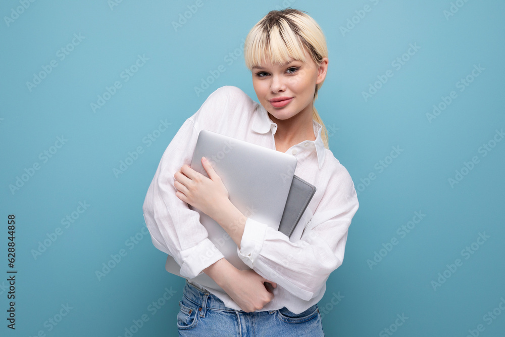 young successful pretty blond office worker woman in white shirt and jeans with laptop and paperwork young successful pretty blond office worker woman in white shirt and jeans with laptop and paperwork