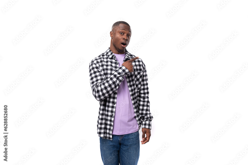 a confused 30 year old african guy dressed in a plaid black and white shirt shrugs his shoulders against the background with copy space a confused 30 year old african guy dressed in a plaid black and white shirt shrugs his shoulders against the background with copy space
