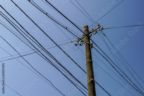 A street sign hanging from a wire Pole with wires Asia. High quality photo