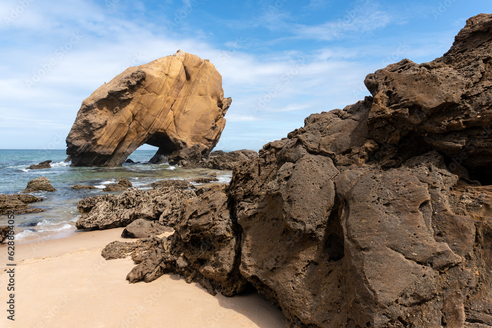 Santa Cruz beach with its famous natural arch formation at sunset, Portugal.