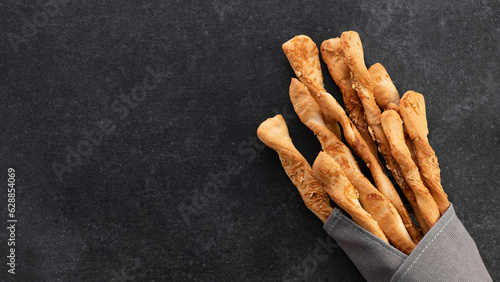 Foto Grissini, bread sticks with parmesan on gray background, top view, place for tex