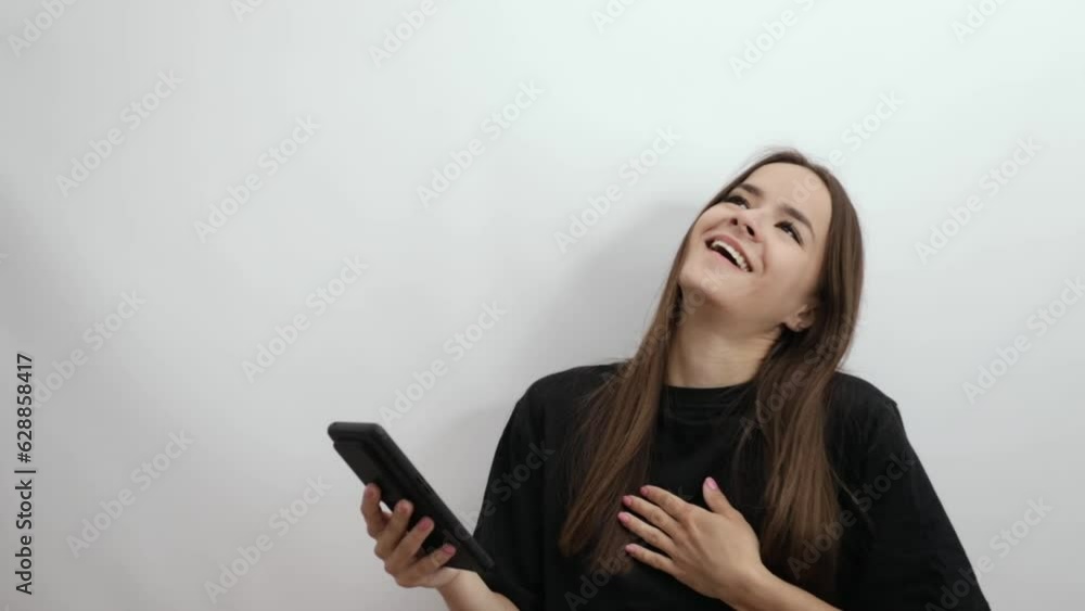 a teenager girl with a phone watches social networks, makes purchases in internet store, a young woman uses an application on a smartphone,online shopping a teenager girl with a phone watches social networks, makes purchases in internet store, a young woman uses an application on a smartphone,online shopping