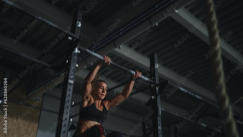 Professional Sportswoman Training On Crossbar, Doing Exercise For Developing Arms And Abs Muscles Professional Sportswoman Training On Crossbar, Doing Exercise For Developing Arms And Abs Muscles