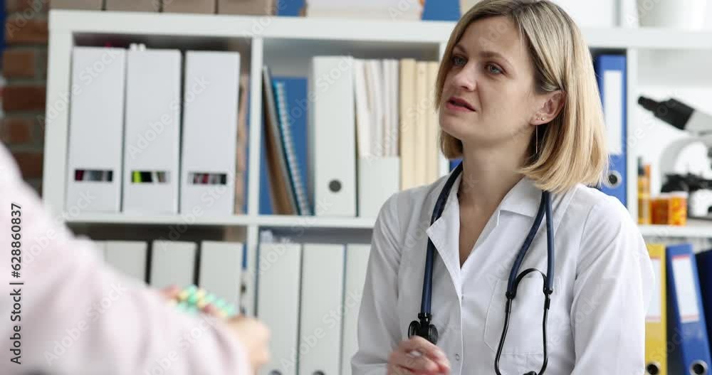 The doctor prescribes pills to a patient in a wheelchair, close-up. Consultation with a traumatologist, rehabilitation after an injury The doctor prescribes pills to a patient in a wheelchair, close-up. Consultation with a traumatologist, rehabilitation after an injury