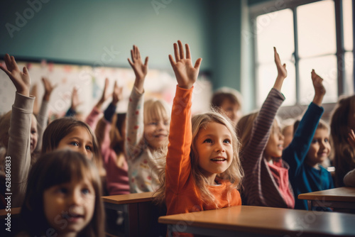 Students raising their hands in class at the elementary school photo