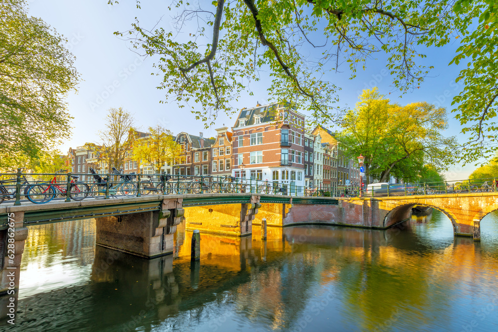 Amsterdam in the morning sun. Traditional old houses and bridges of Amsterdam. Beautiful morning in Amsterdam.