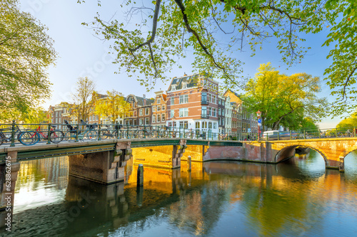 Amsterdam in the morning sun. Traditional old houses and bridges of Amsterdam. Beautiful morning in Amsterdam.