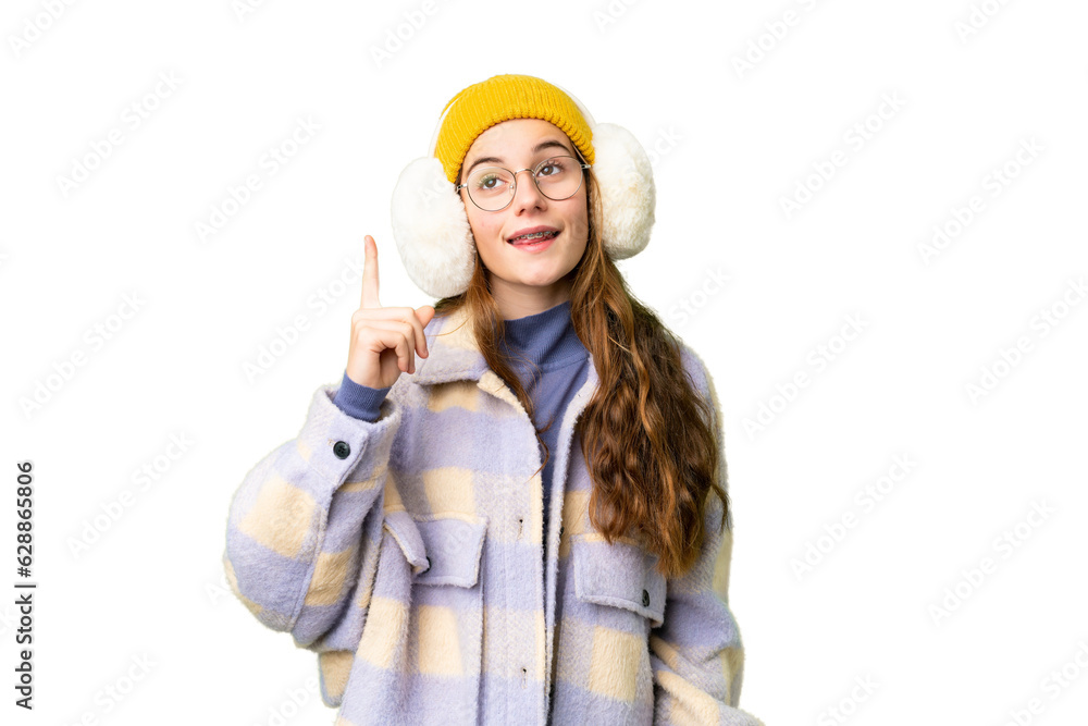 Teenager girl wearing winter muffs over isolated chroma key background intending to realizes the solution while lifting a finger up
