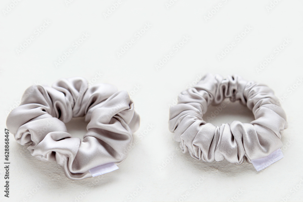 Obraz premium silver silk Scrunchy on white background. Hairdressing tool of Colorful Elastic Bobble Hairband.